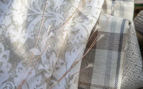 Tan, plaid, floral fabrics folded and stacked