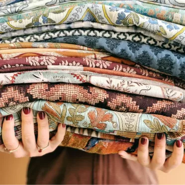 Hands holding a stack of fabrics